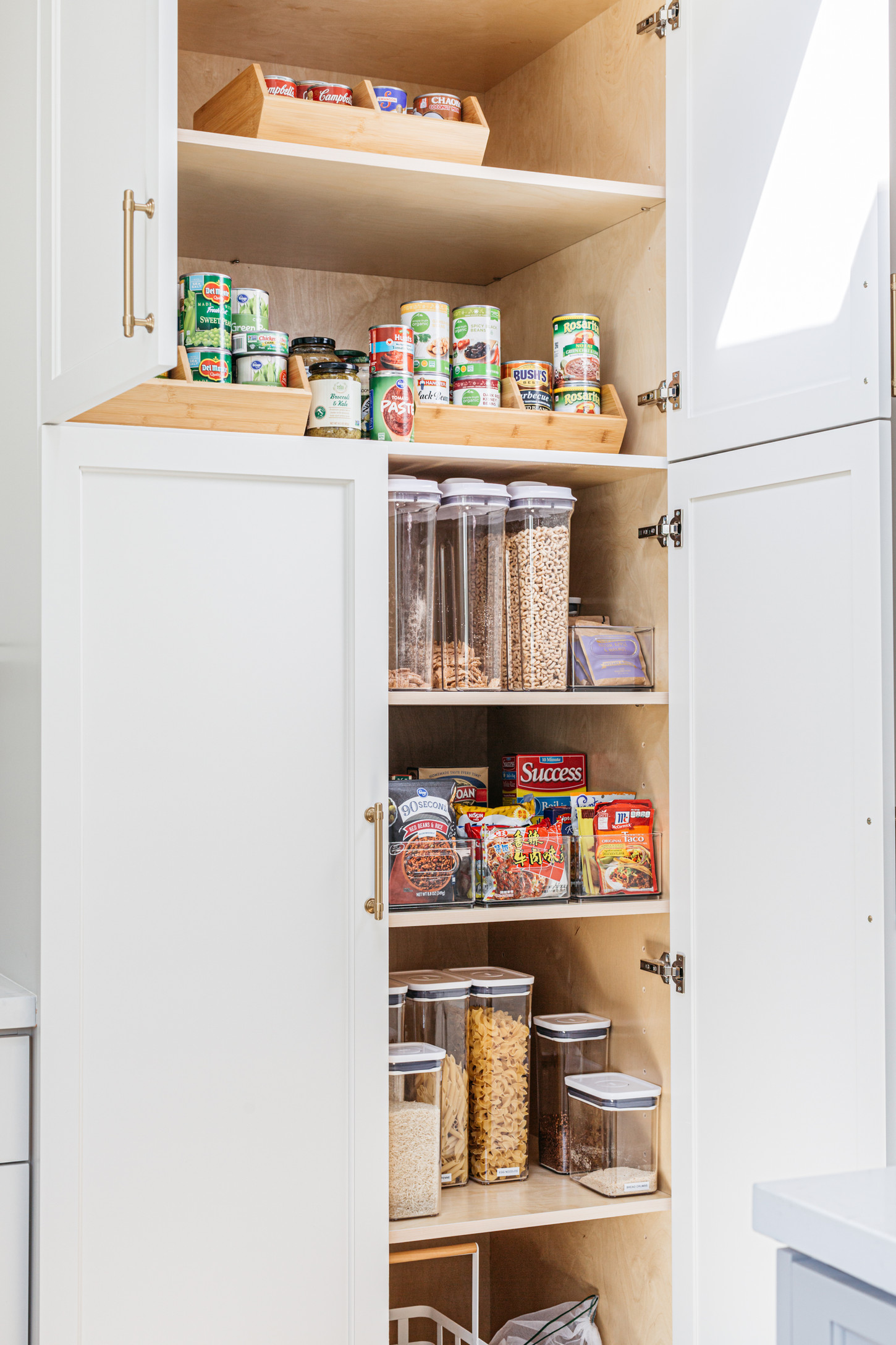 Kitchen storage cabinets full of jars and bowls