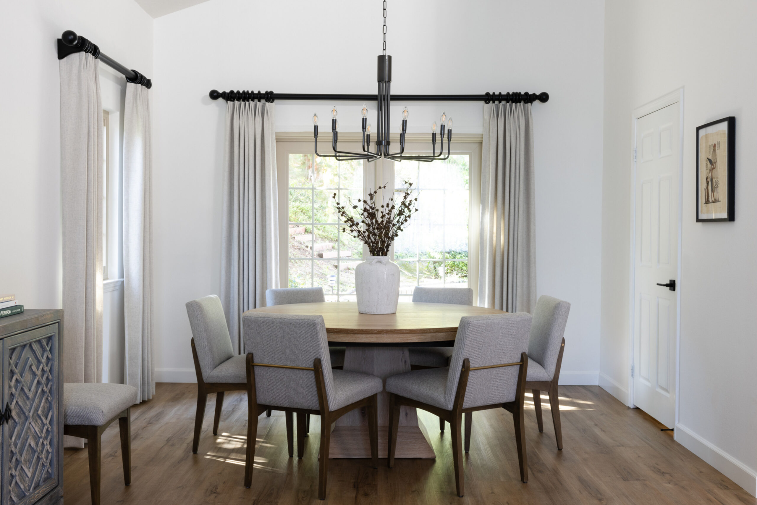 A dining room decor with white color effect featuring round table and chairs